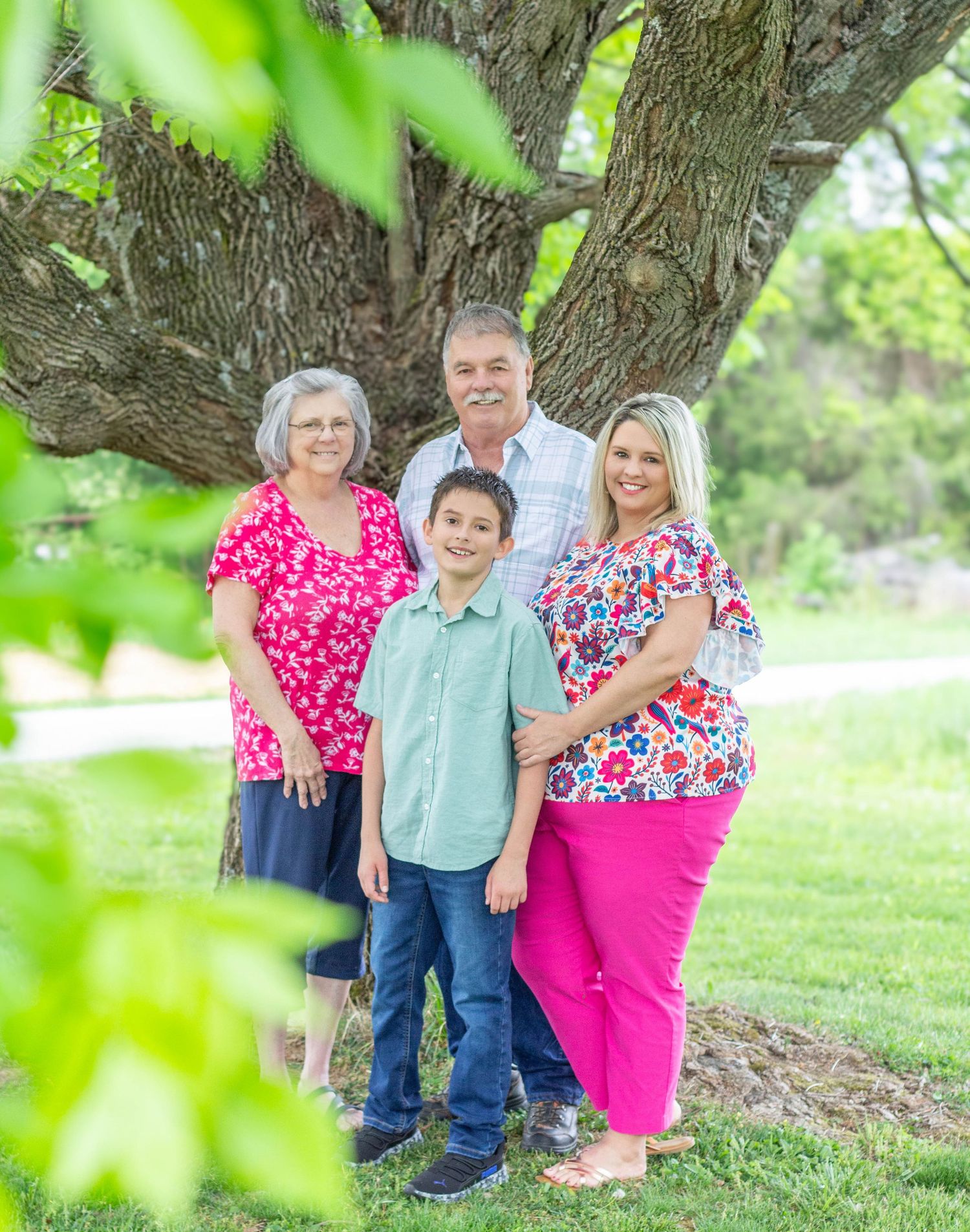 Grandparents posing with their daughter and grandson during a family session