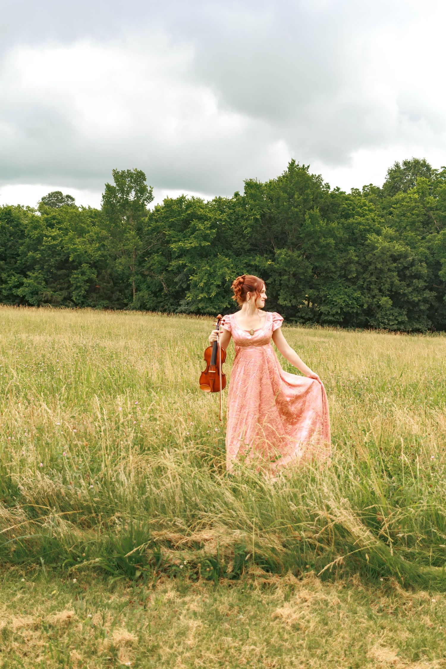 Bride walking through an open field in her wedding dress.