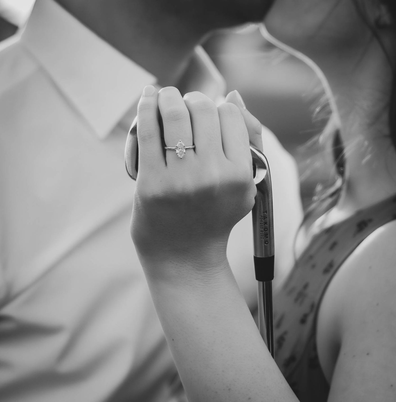 Black-and-white close-up of an engagement ring during a couples session.
