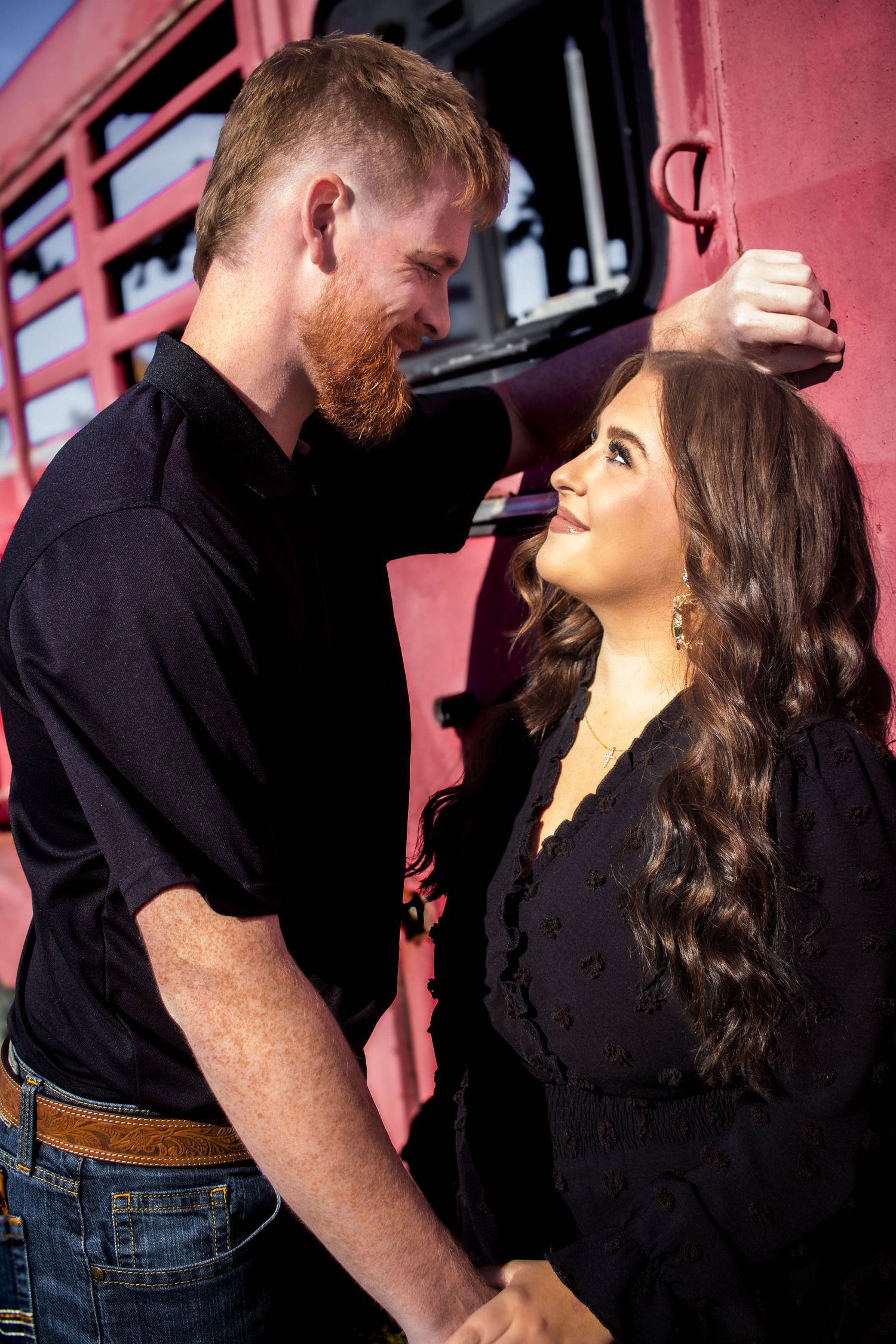 Couple holding hands and smiling together during a casual portrait session.