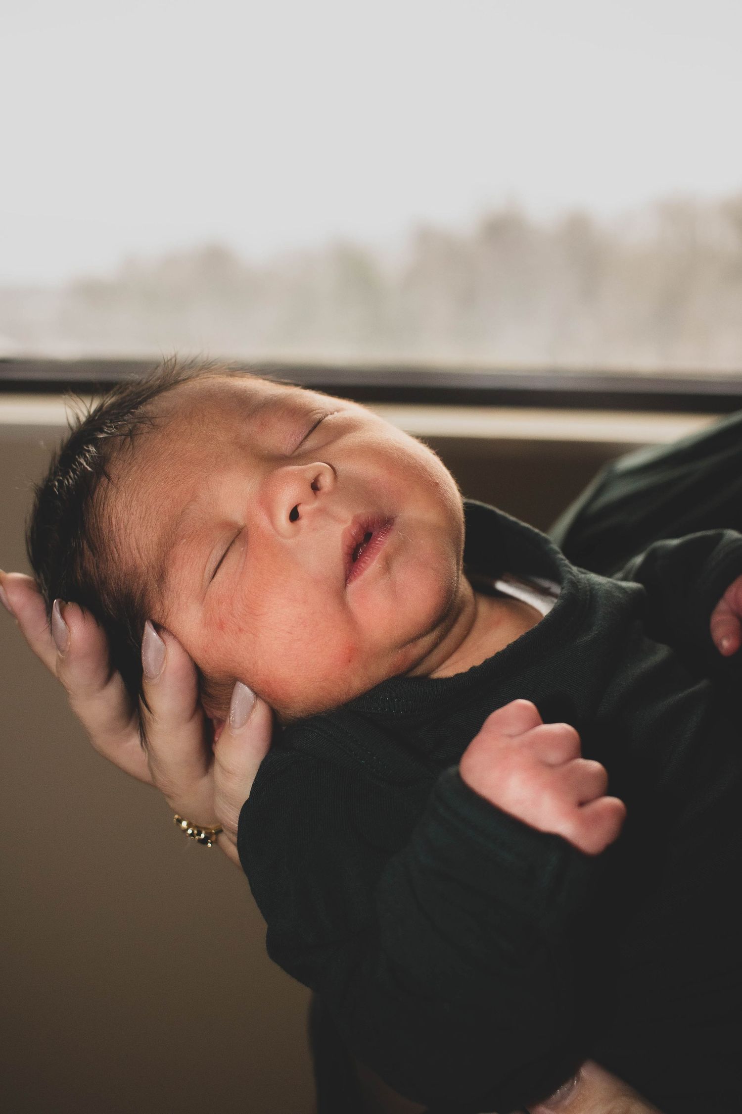 Newborn baby resting peacefully during a hospital photography session.