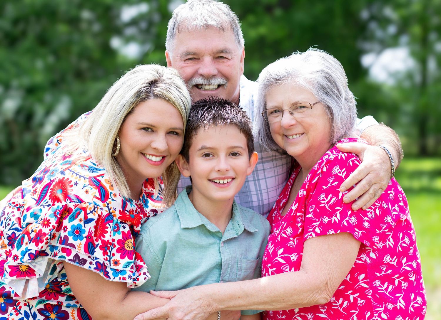 Grandparents posing for close up with their daughter and grandson during a family session