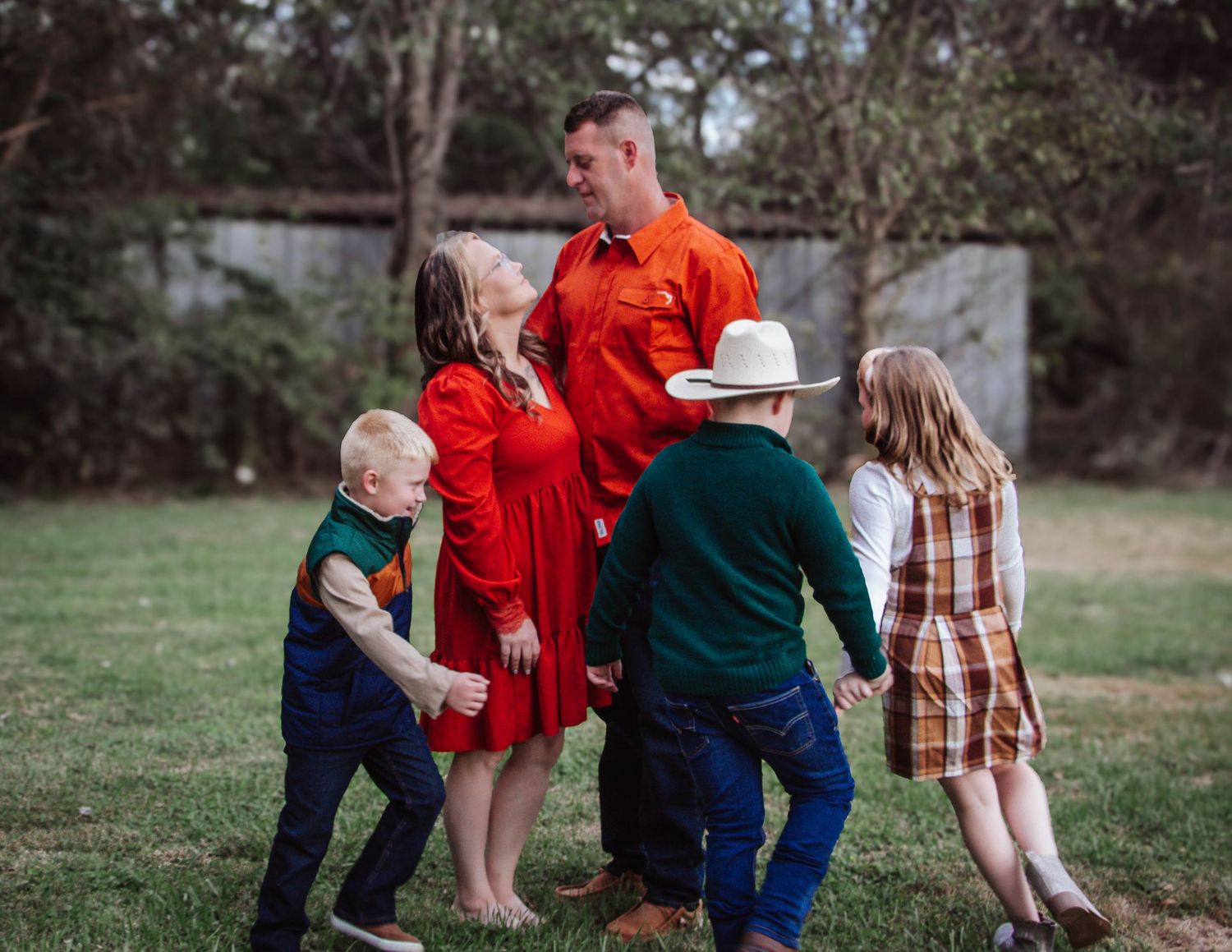 Large family posing together outdoors in coordinated fall outfits