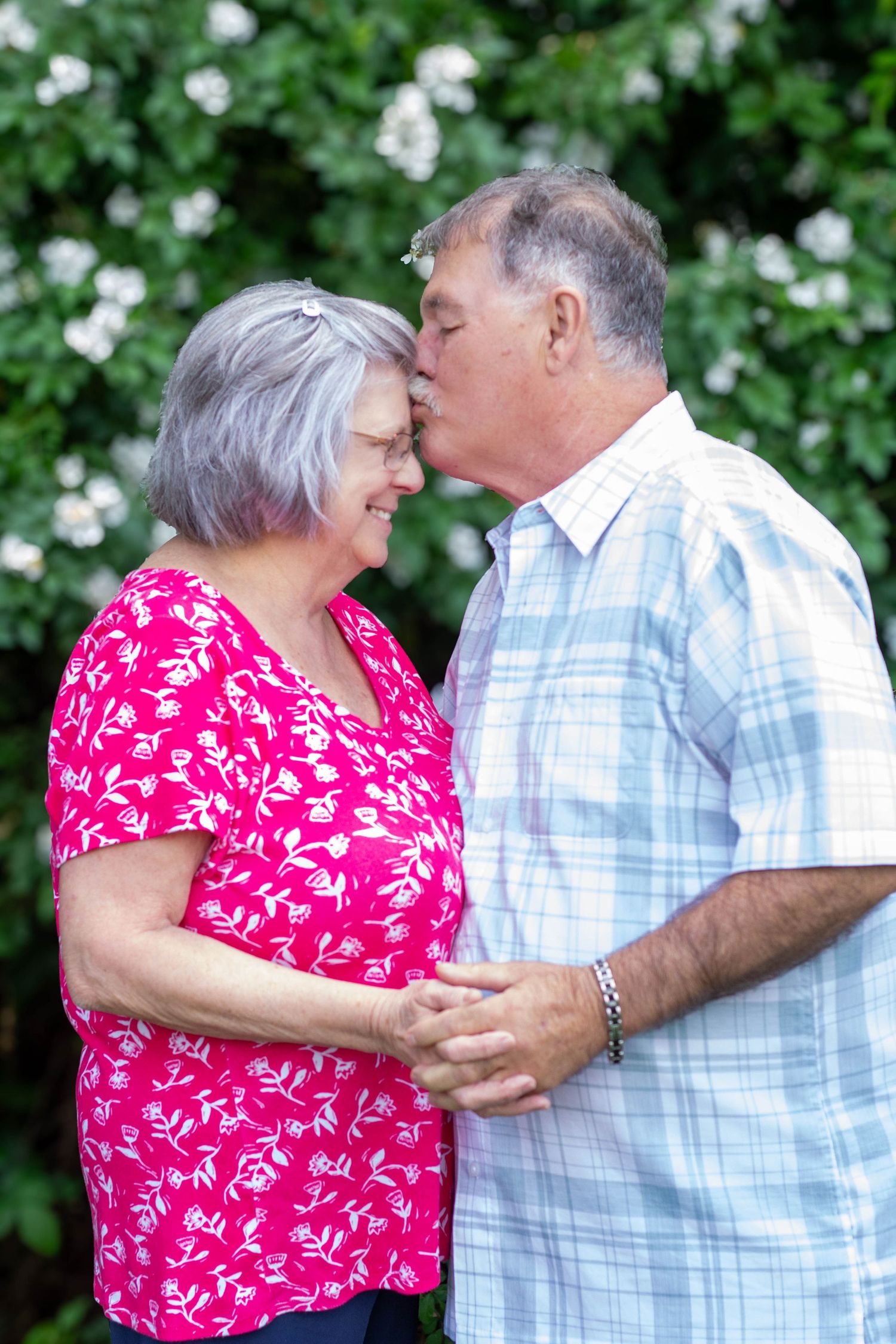 Older couple sharing a sweet kiss outdoors during a family photography session