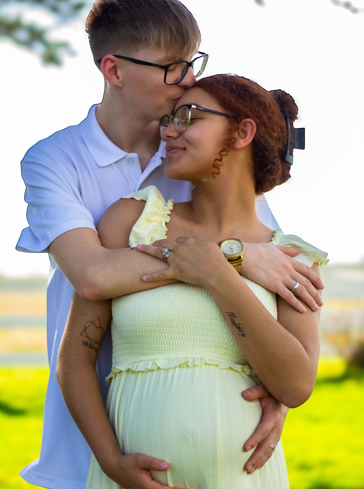 Expecting father embracing the mother from behind during a maternity session.