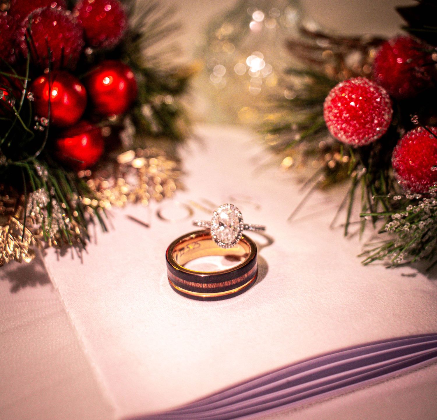 Wedding rings photographed beside red floral reception details