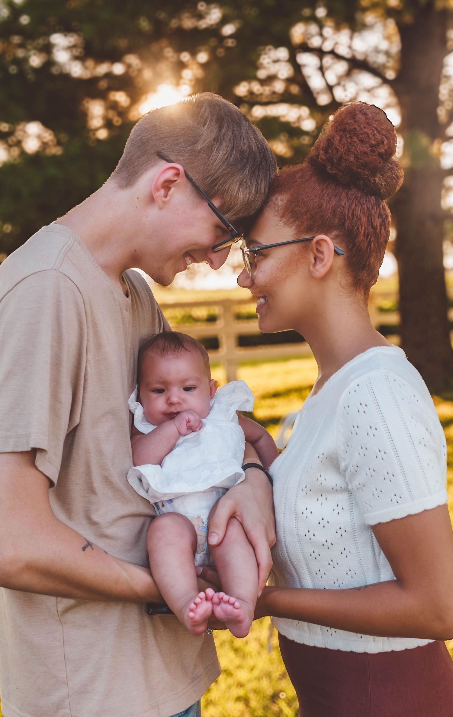 Parents holding their newborn baby together during a golden-hour family session
