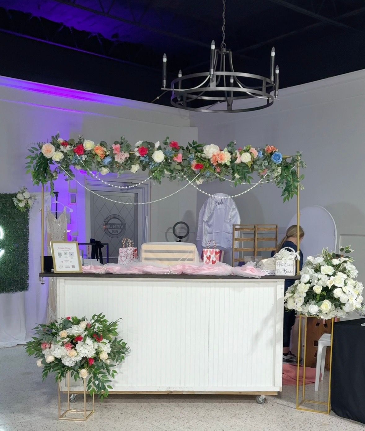 Mobile wedding bar decorated with colorful florals and greenery