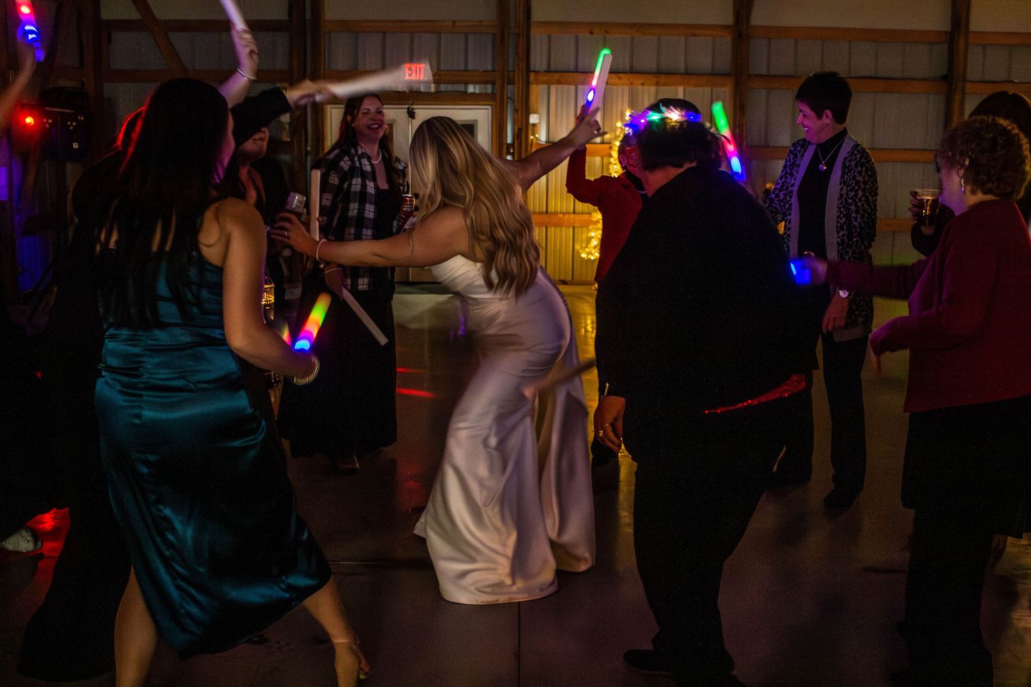 Wedding guests and bride dancing together during the reception.