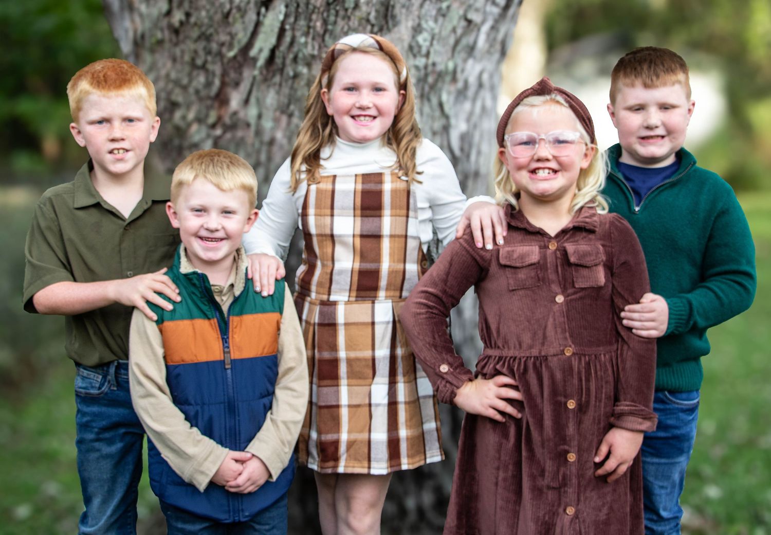 cousins posing together outdoors in coordinated fall outfits
