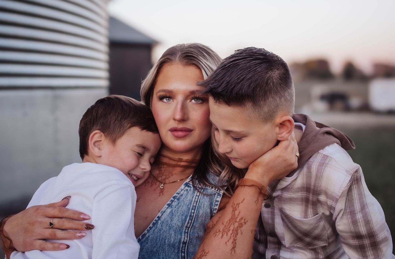 Mother embracing her two sons during a close-up family portrait.