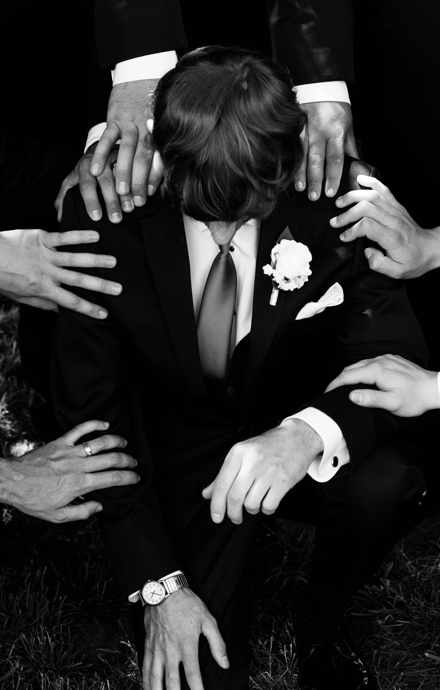 Black-and-white portrait of a groom surrounded by his groomsmen