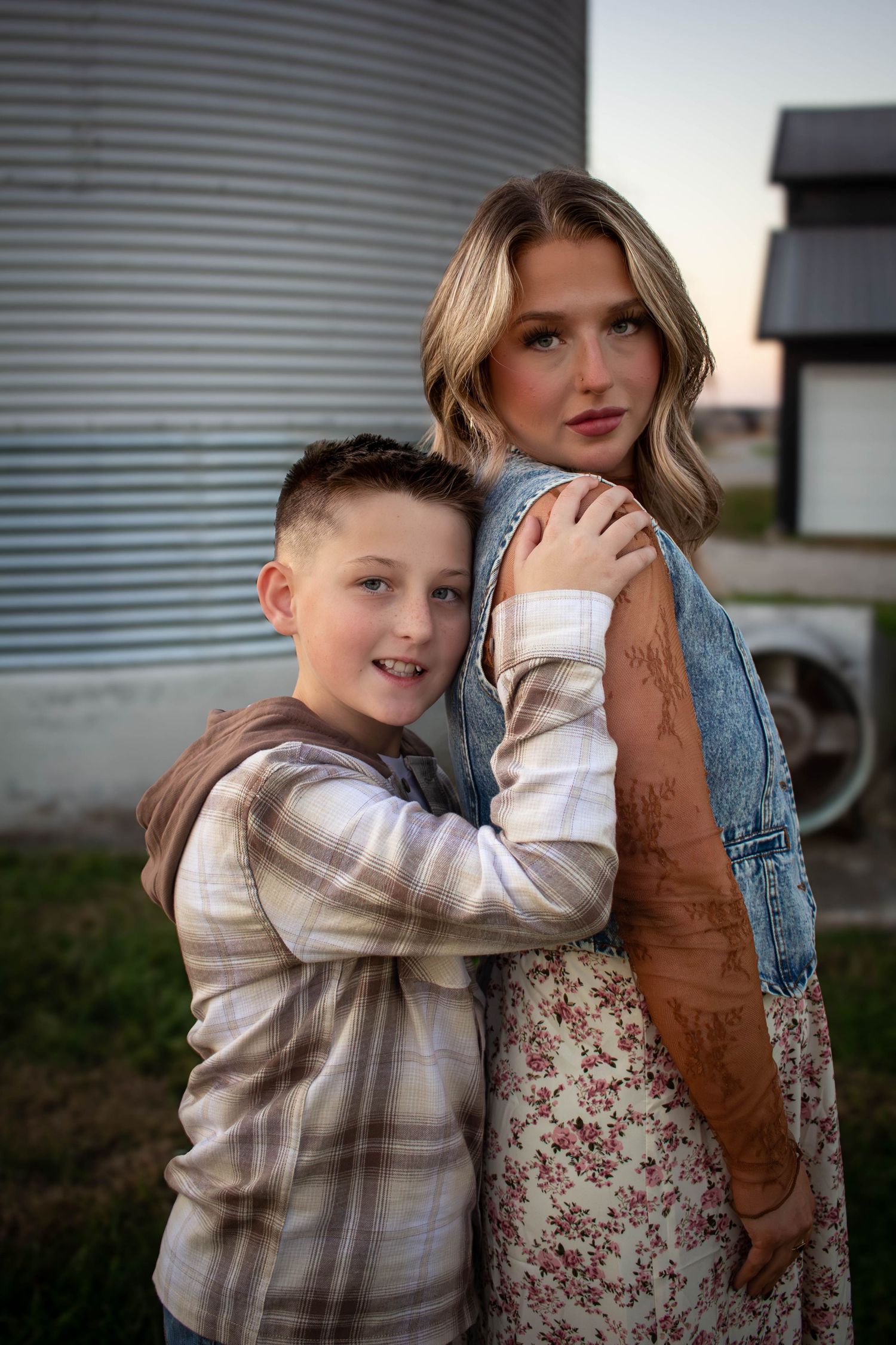 Mother posing outdoors with her son during a family photography session.