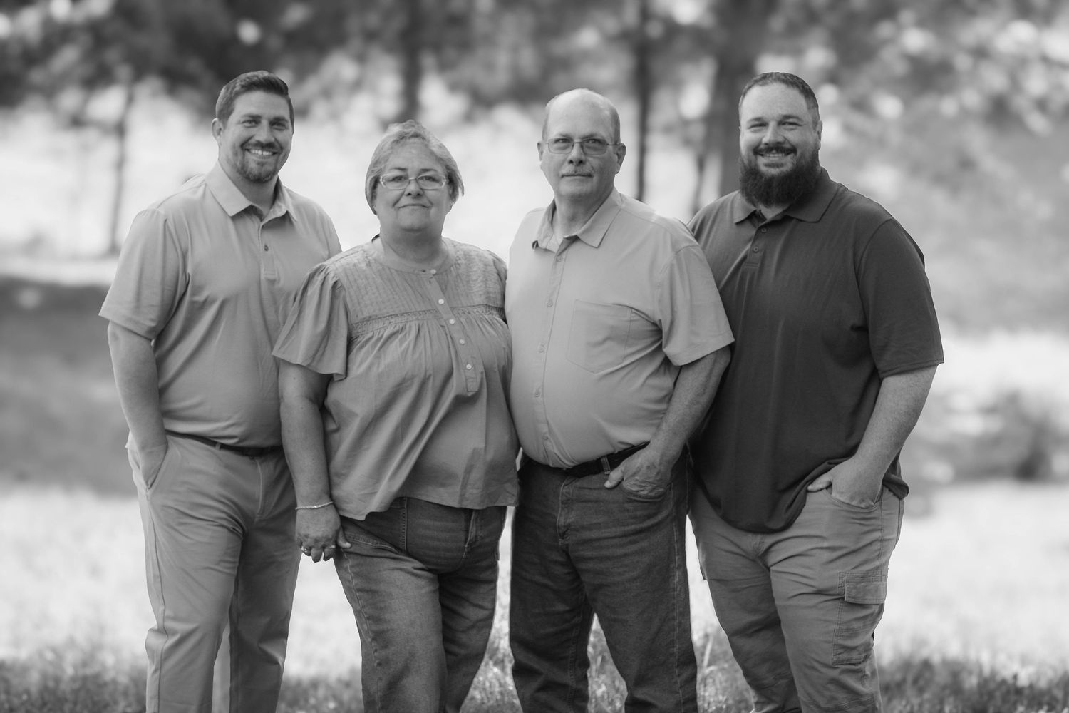 Parents and adult sons posing for black and white outdoor portrait