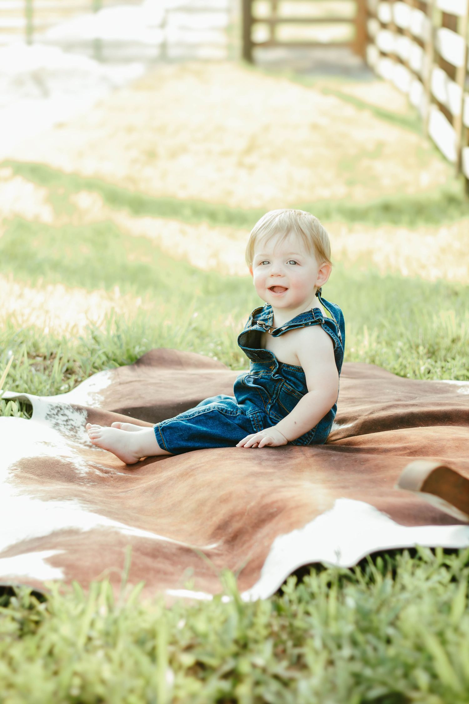 Baby sitting on a blanket outdoors during a milestone photography session.