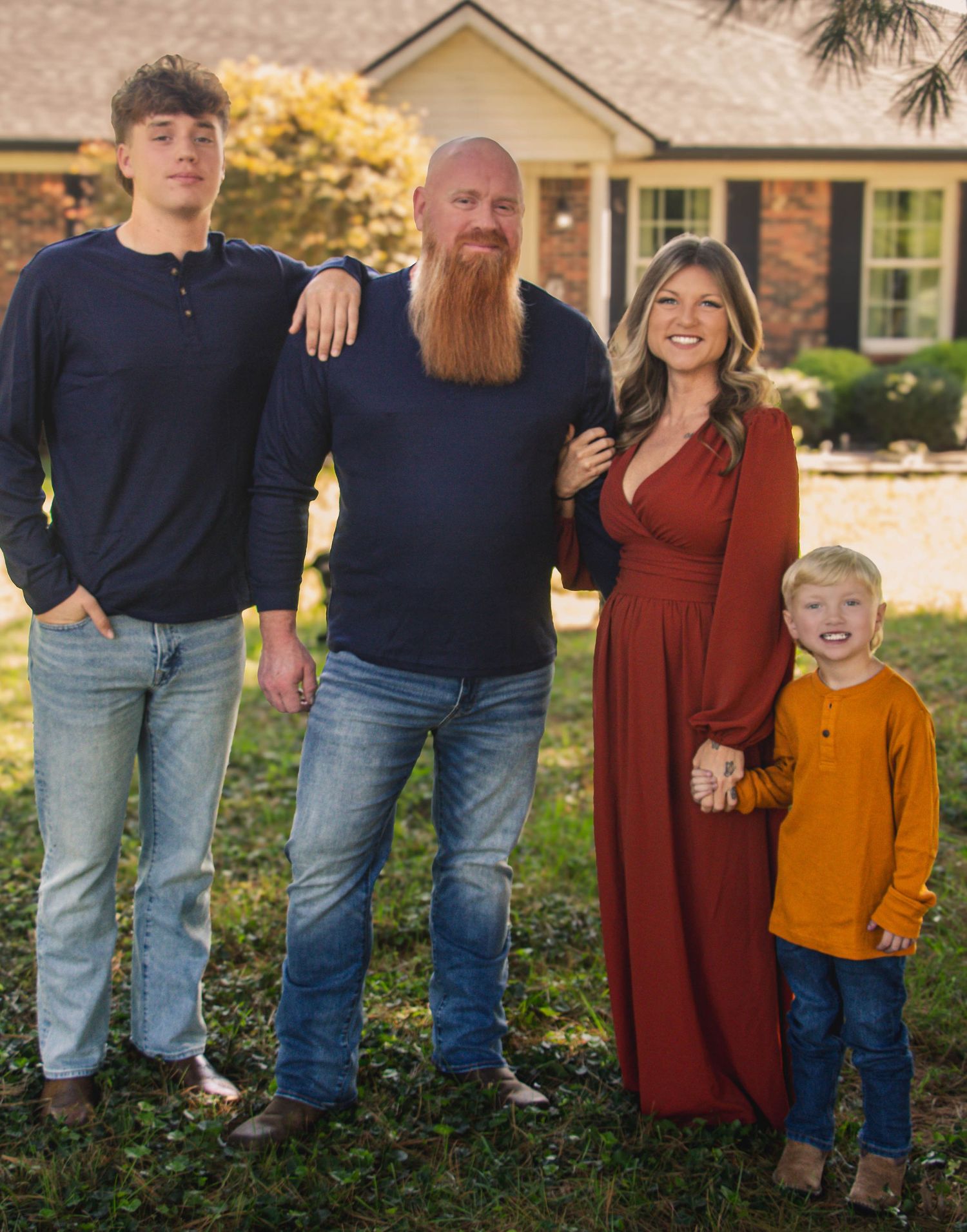 family posing together outdoors in coordinated fall outfits