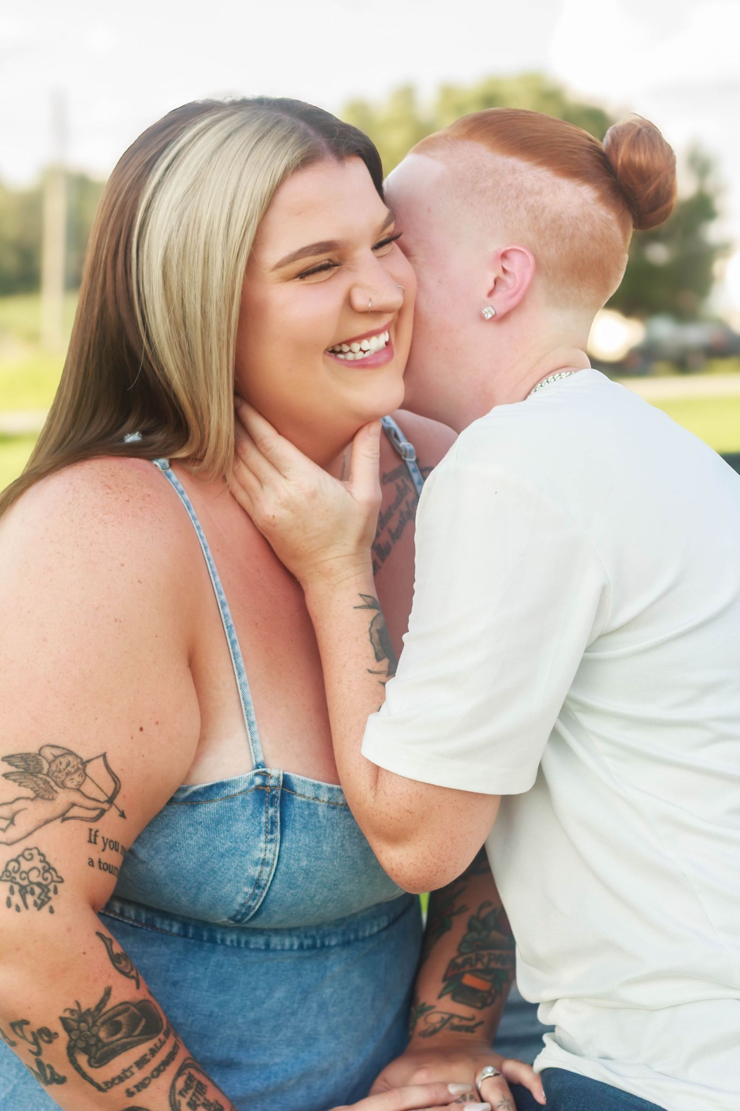 Playful couple laughing and embracing outdoors.