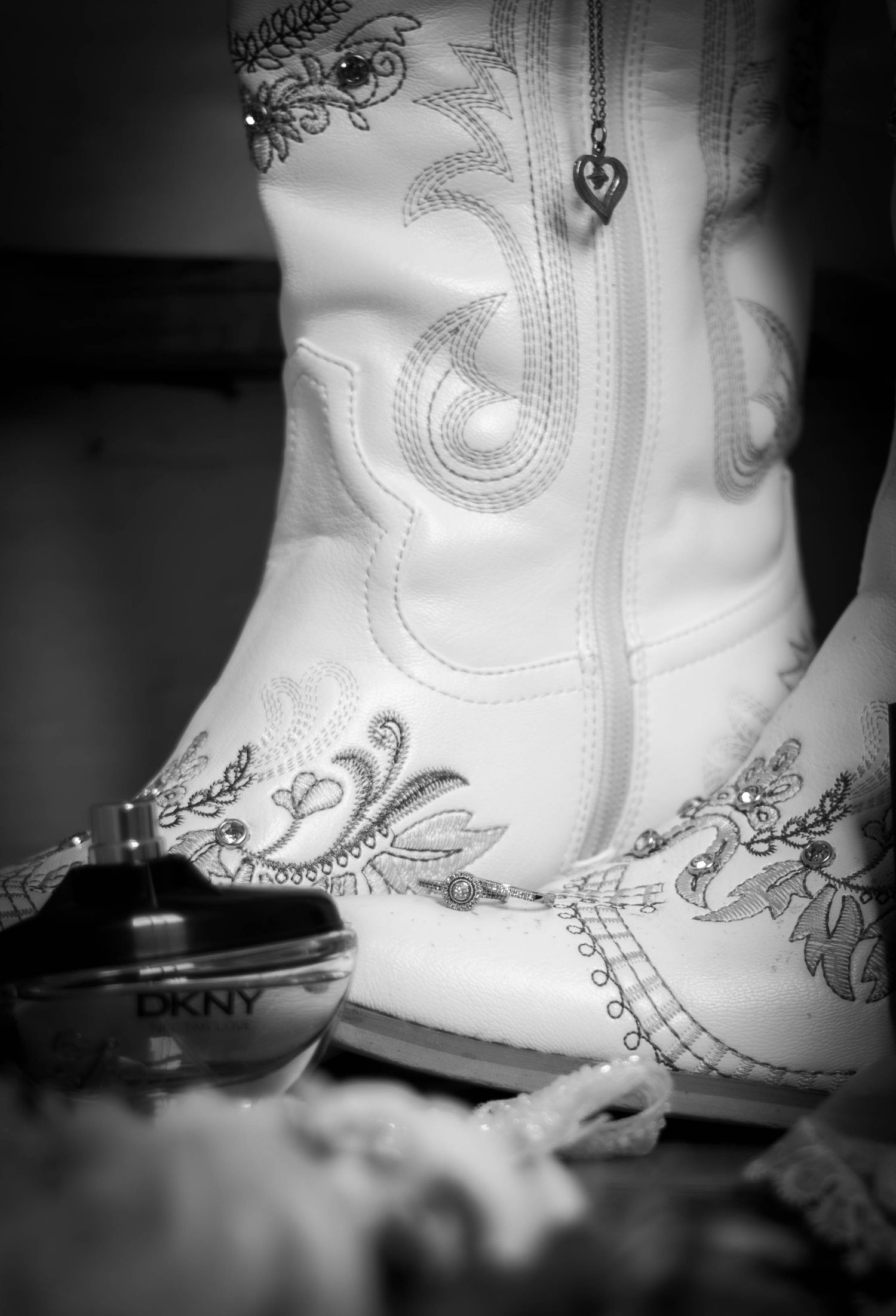 Black-and-white close-up of bridal shoes and wedding accessories.