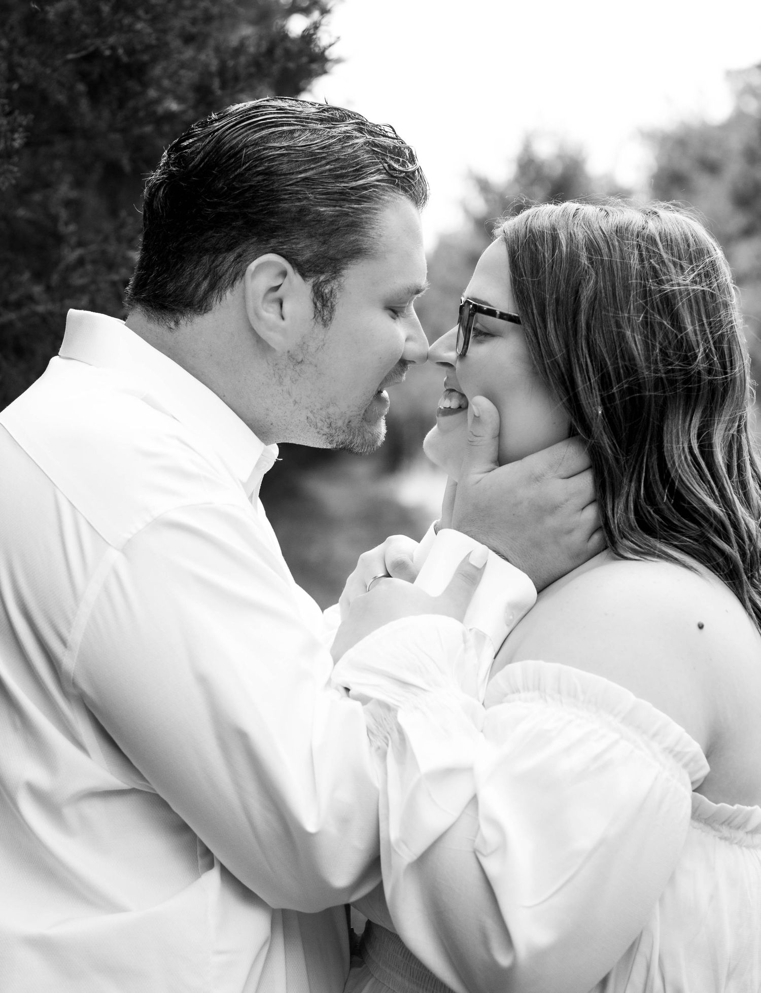 Black-and-white close-up of a couple kissing during their engagement session.