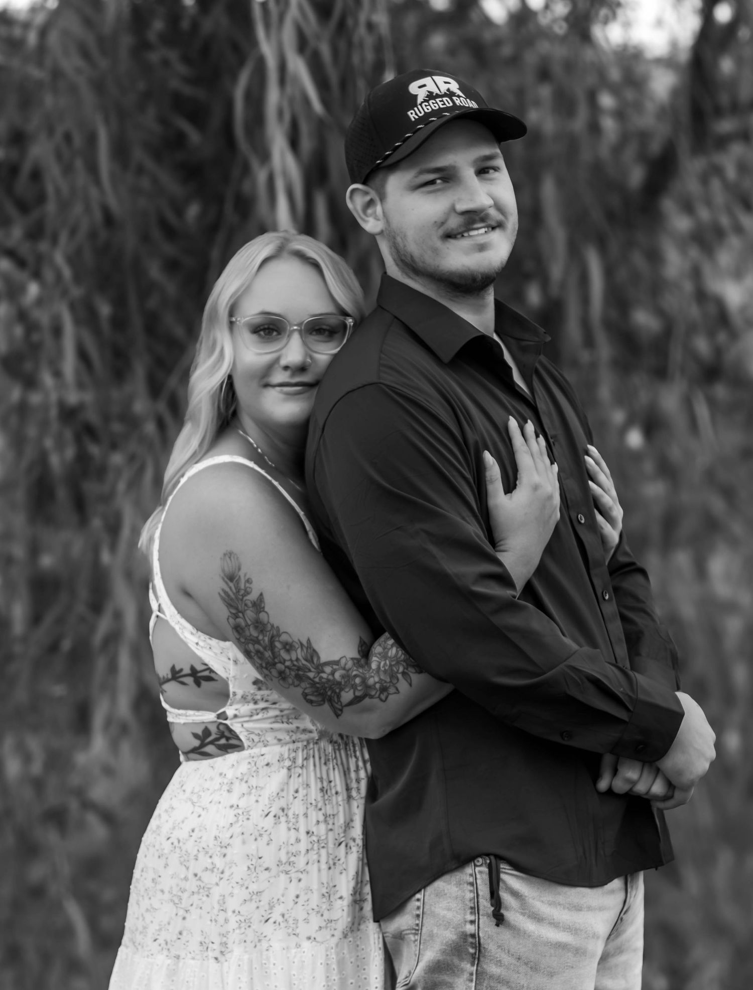 Couple posing together outdoors during a black and white portrait session.