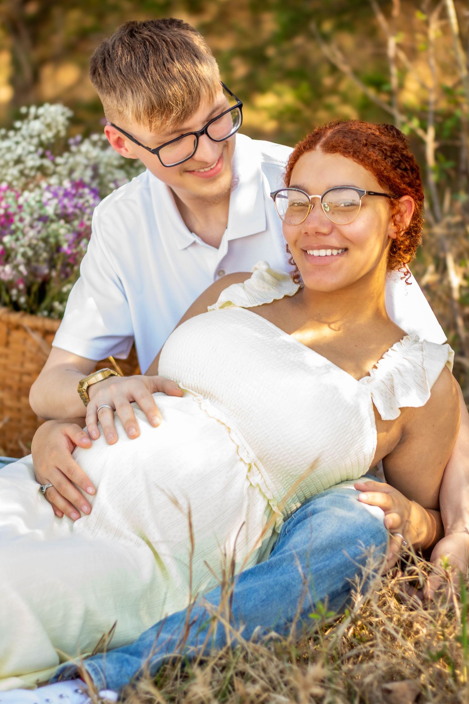 Expecting couple smiling together during an outdoor maternity session.