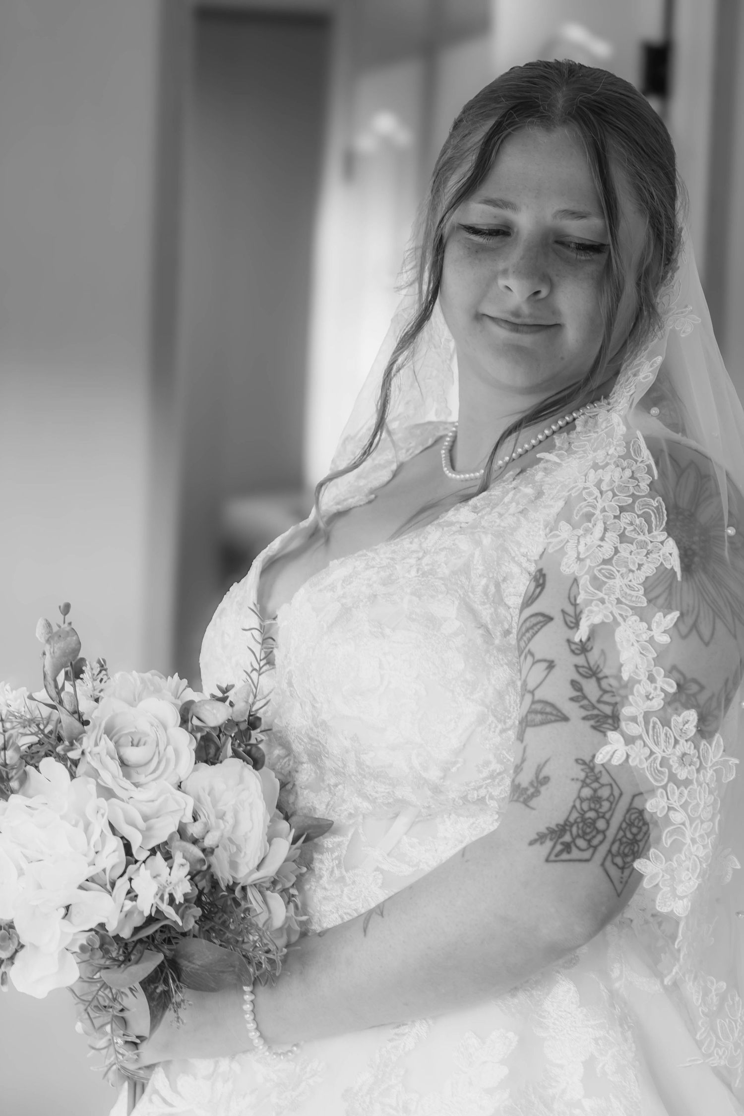Black-and-white bridal portrait of a bride holding her bouquet.