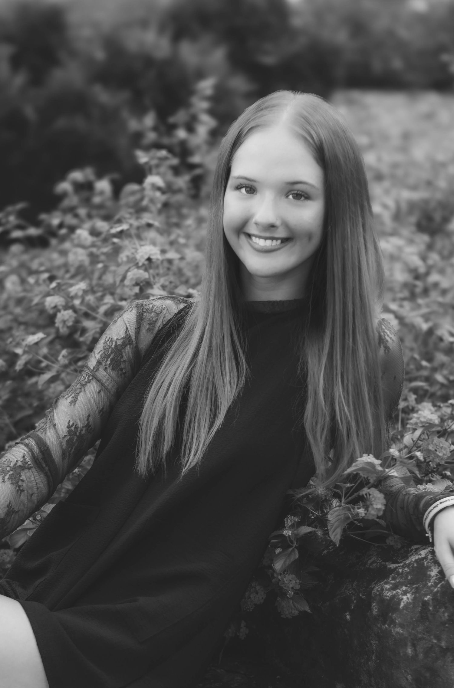 High school senior girl posing outdoors for a senior portrait session in black and white