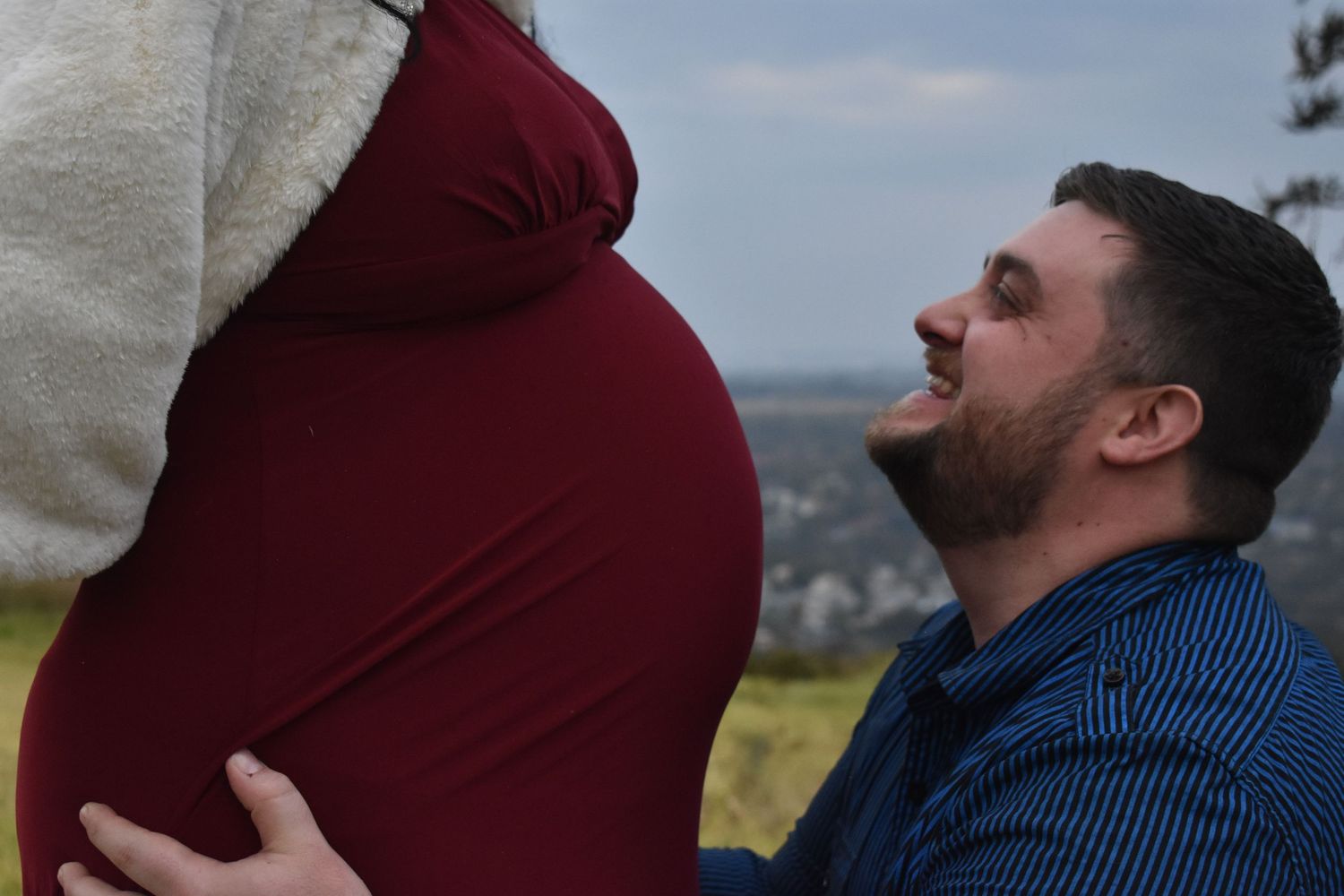 Candid photograph of a soon to be dad and his wife's belly.