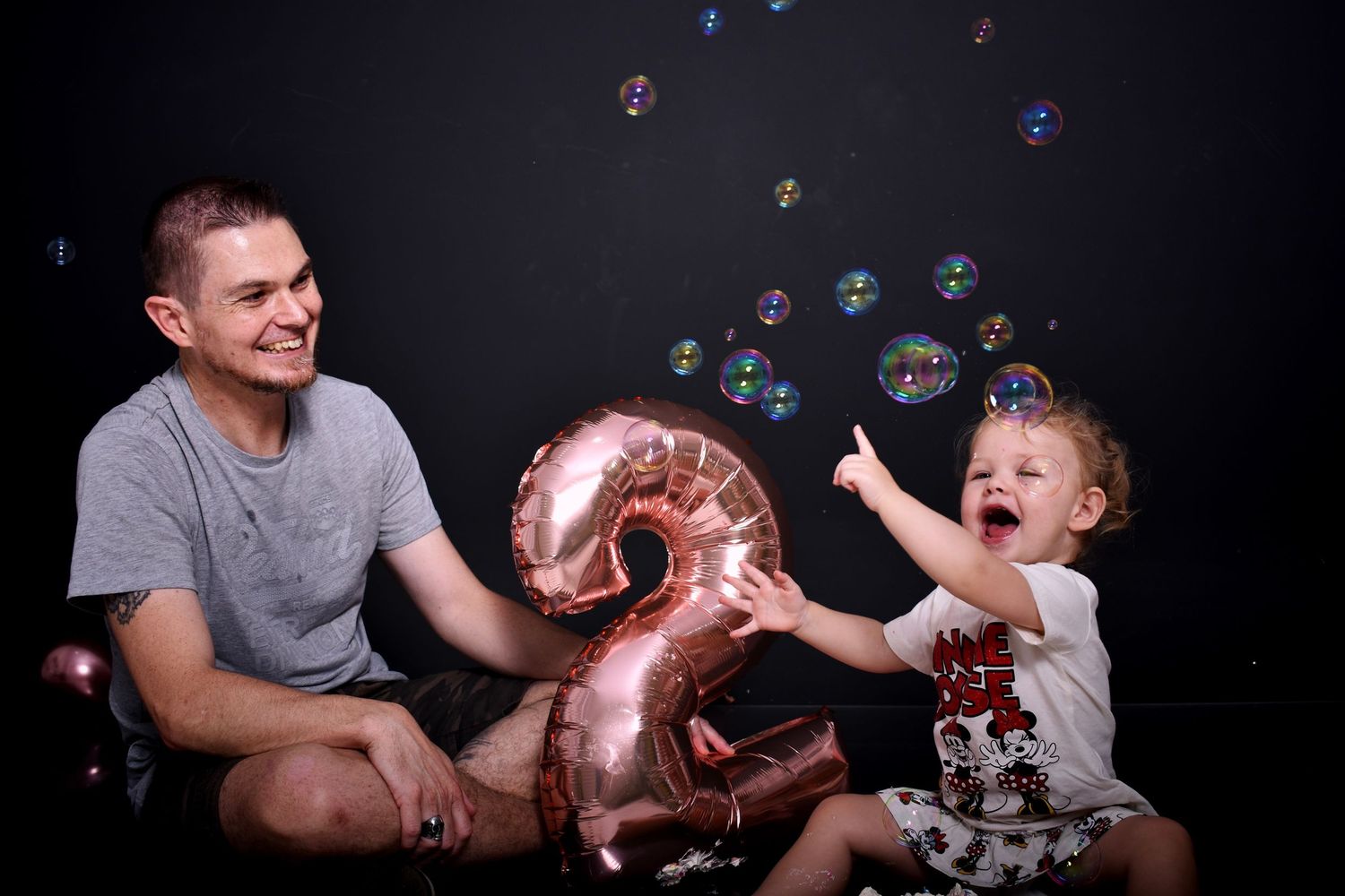Candid picture of the birthday girl and her dad surrounded with bubbles in Pretoria, South Africa.