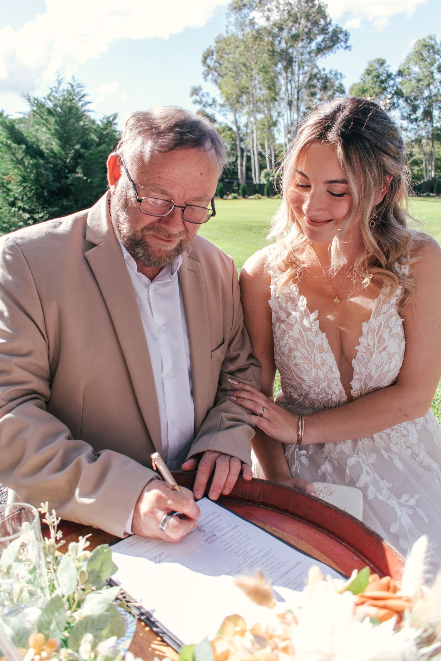 Bride and her father captured signing the marriage certificate.