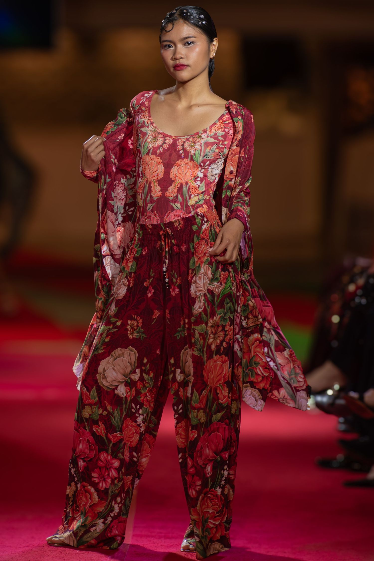 Model posing at the end of a brightly lit fashion runway at a Brisbane event.