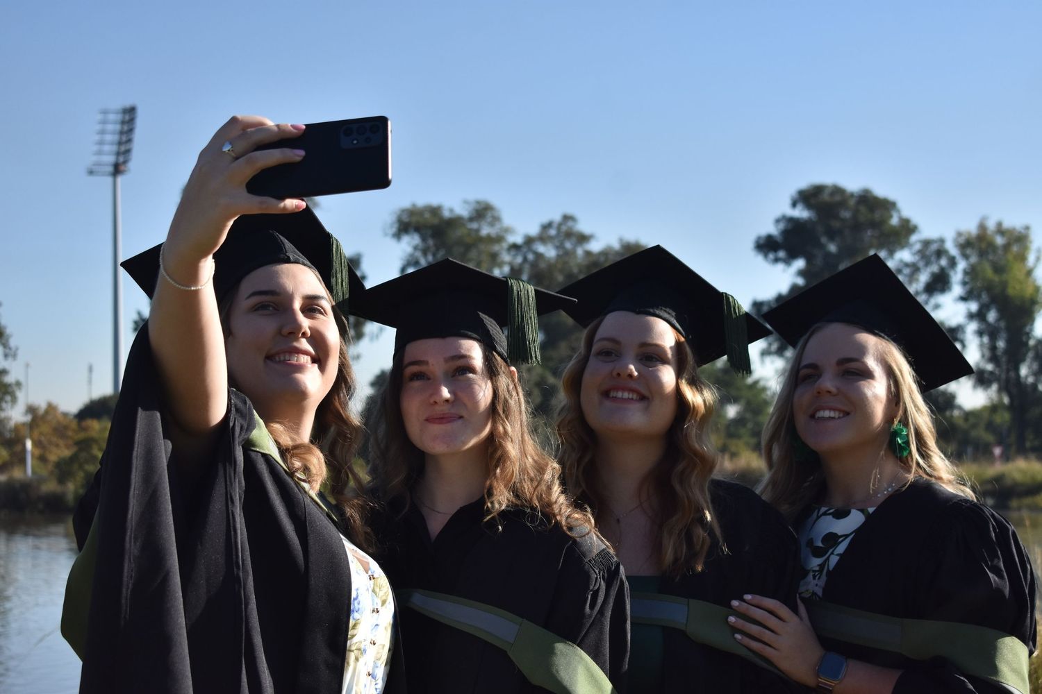 Candid photograph of best friends graduating university together.