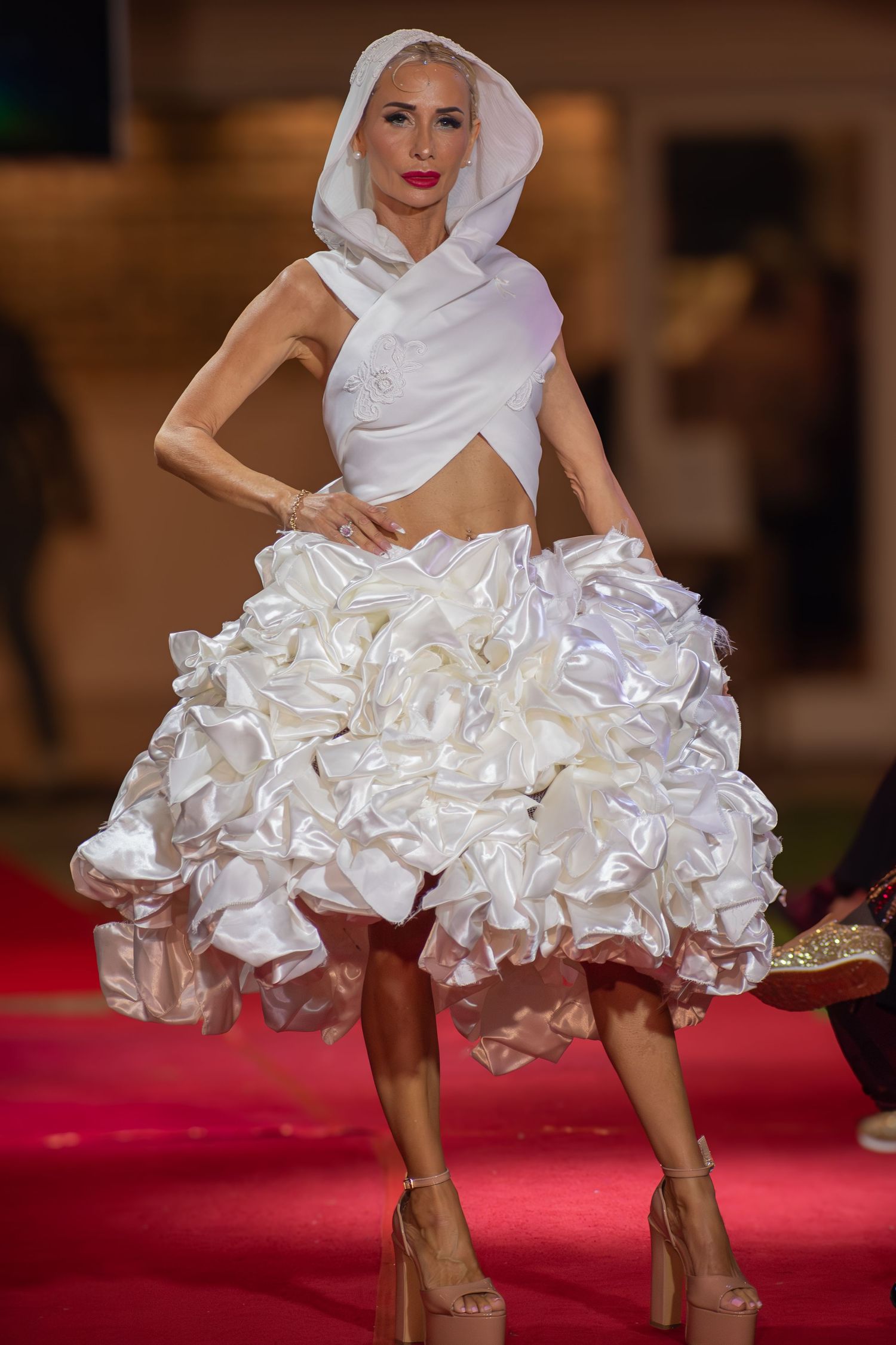 Model posing at the end of a brightly lit fashion runway in Brisbane.