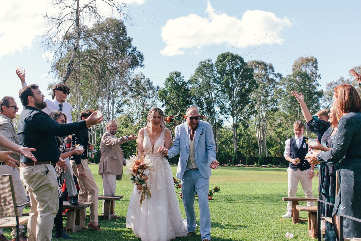 Candid photograph of the bride and groom being celebrated by the wedding guests.