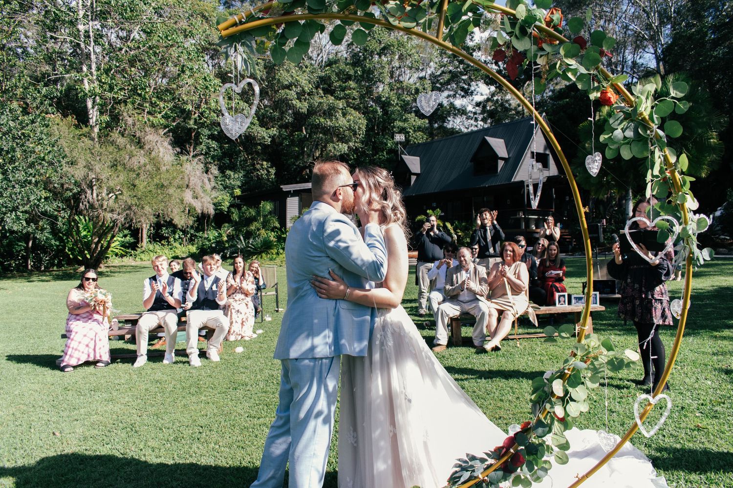 Candid photo of the first kiss of a newlywed couple.
