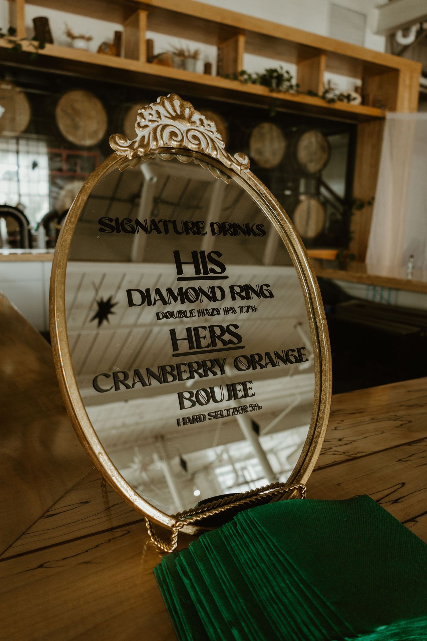 Signature drink sign written on a mirror at the wedding bar