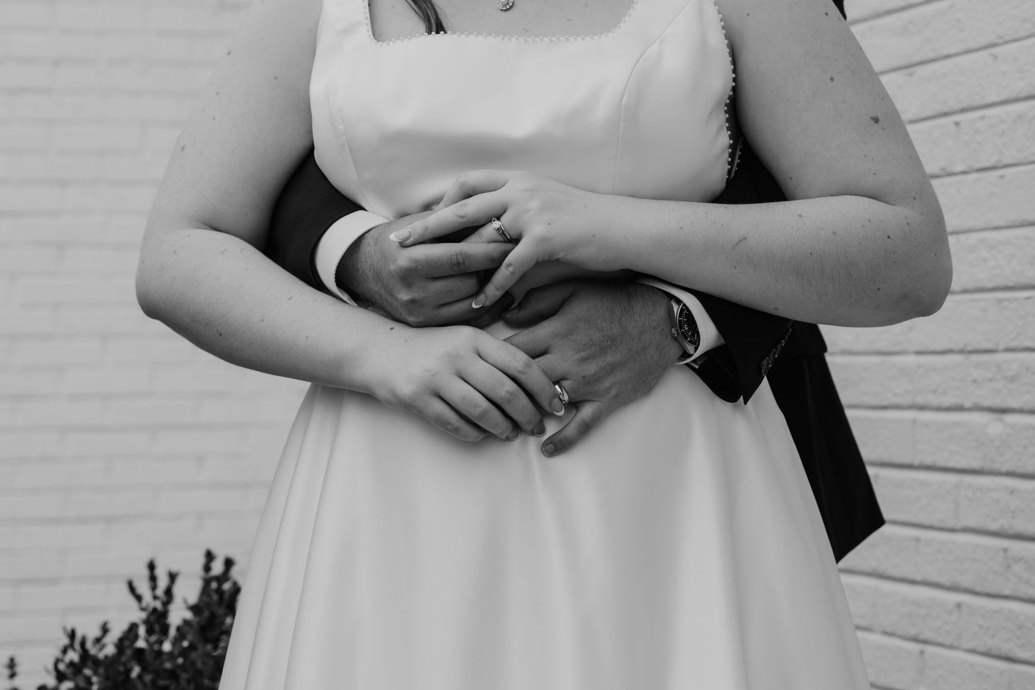 Bride and groom putting rings on in black and white