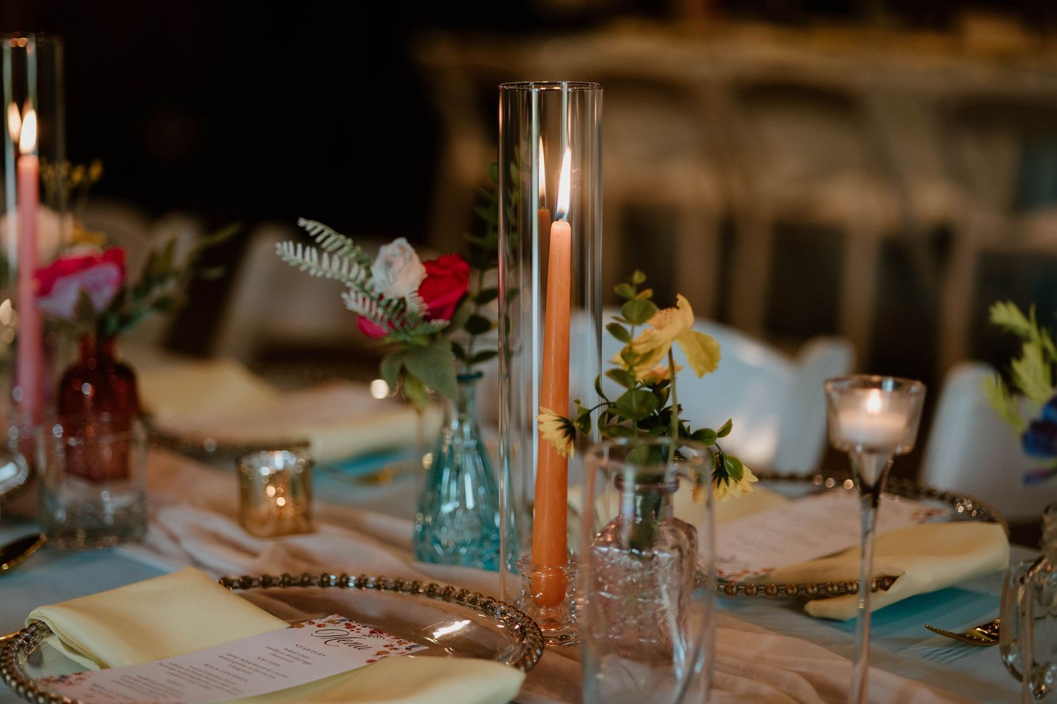 Wedding reception table setting with candles and floral centerpieces