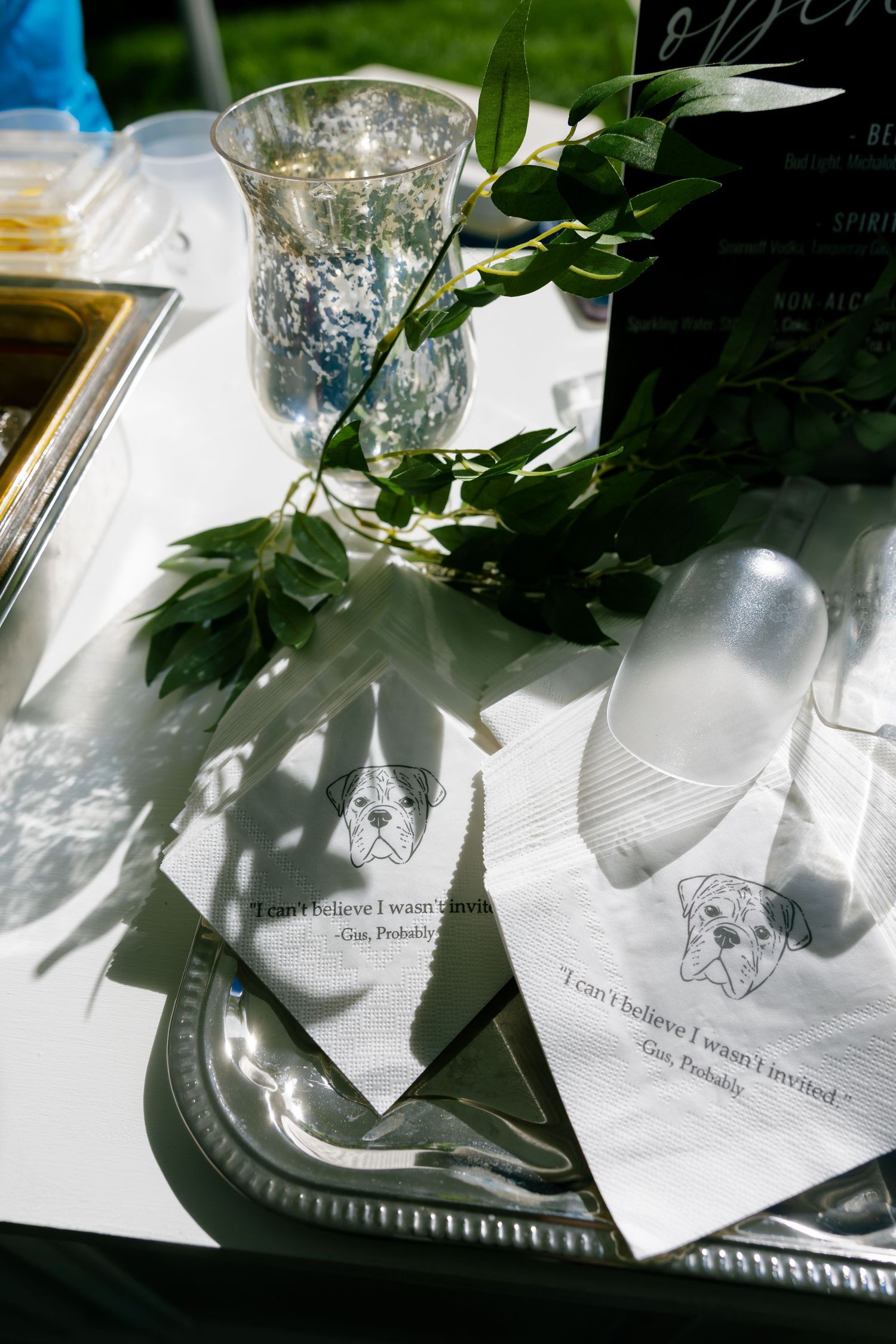 Wedding bar napkins printed with a dog illustration and humorous quote on a silver tray.