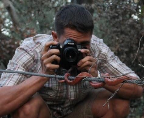 Someone taking photos with a professional camera in an outdoor setting.