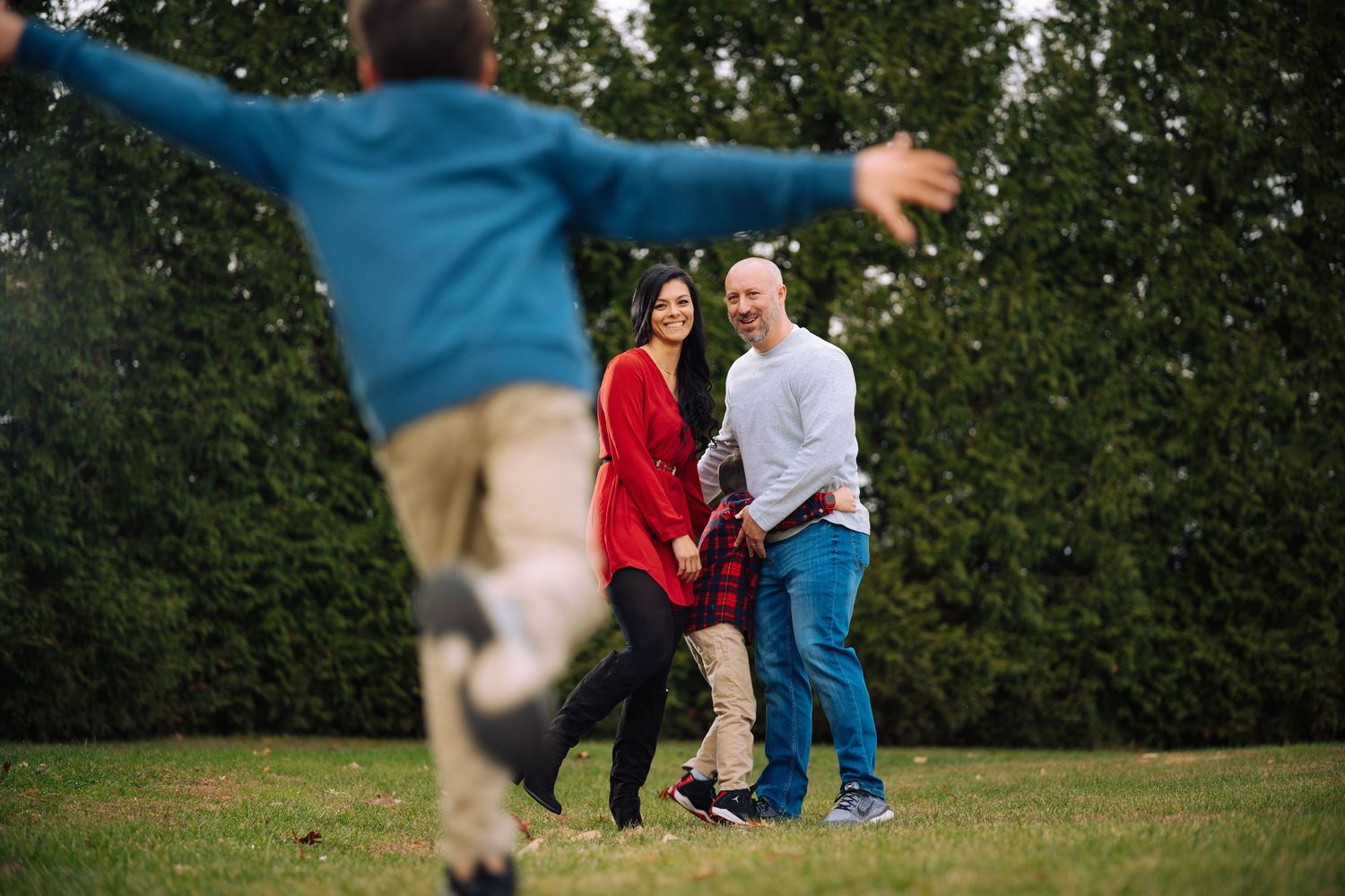 Playful outdoor photo session in a grassy field on a sunny day.