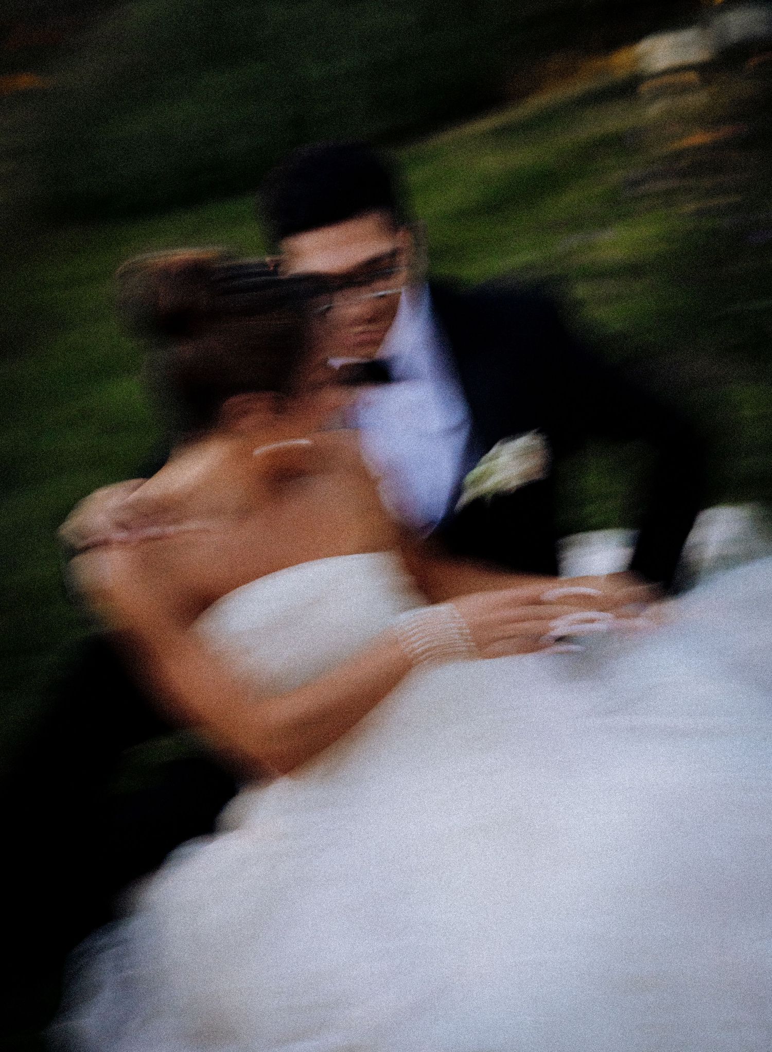 Blurred motion photo of a bride and groom sharing a romantic dance at their outdoor wedding ceremony.