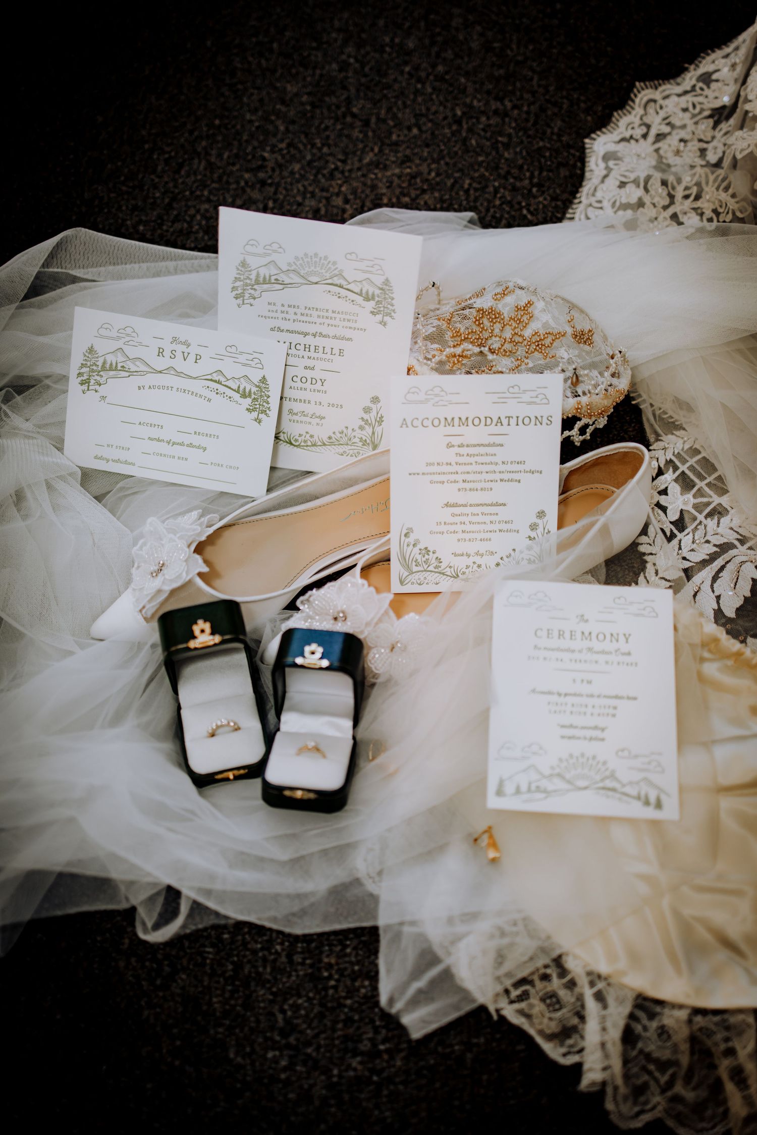 Wedding invitations and ring boxes arranged with delicate white tulle fabric.