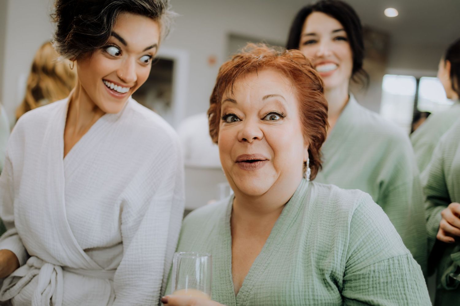 Wedding party members in mint green and white robes getting ready for the ceremony.