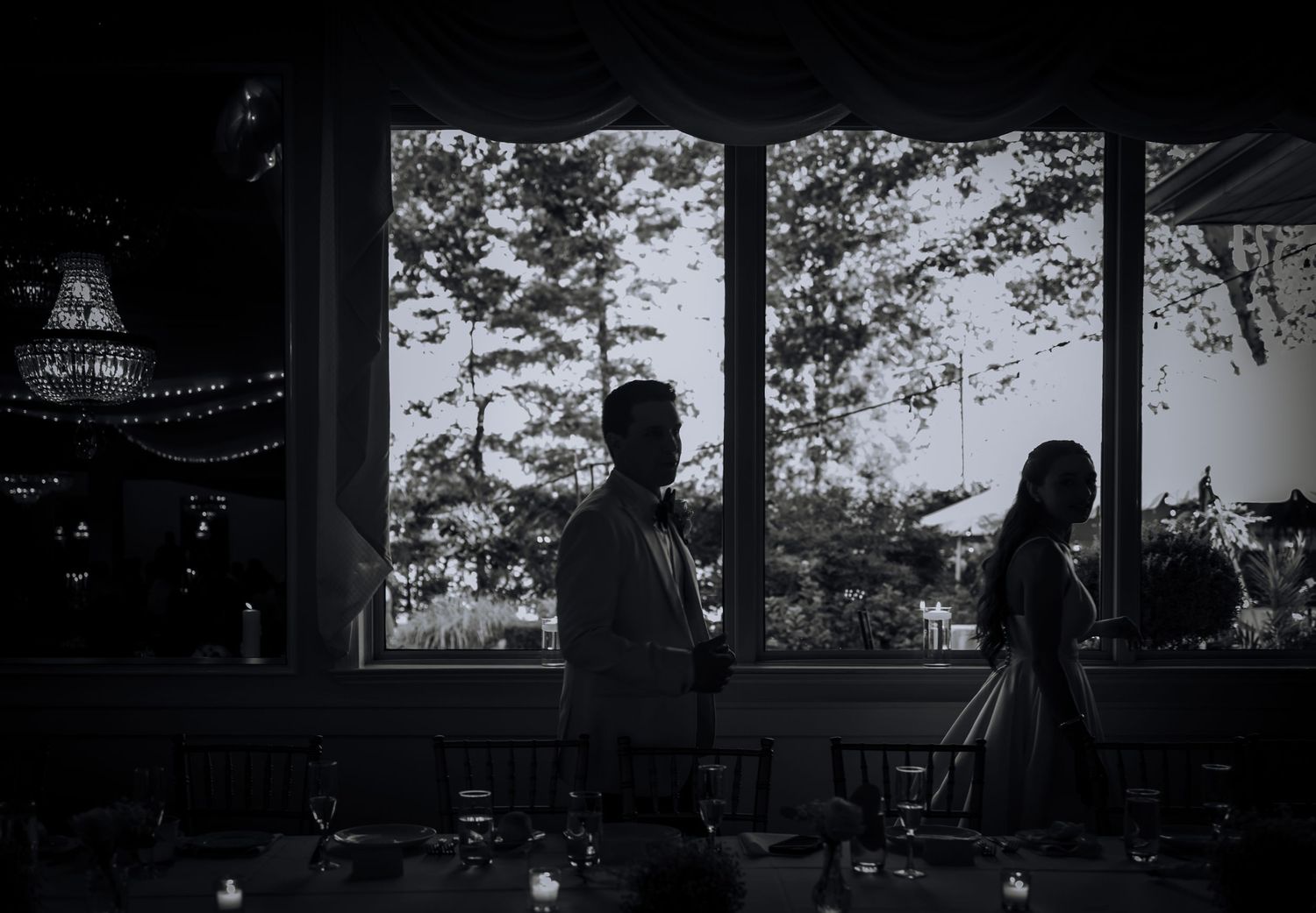 Moody silhouette of wedding reception venue with dramatic window lighting.