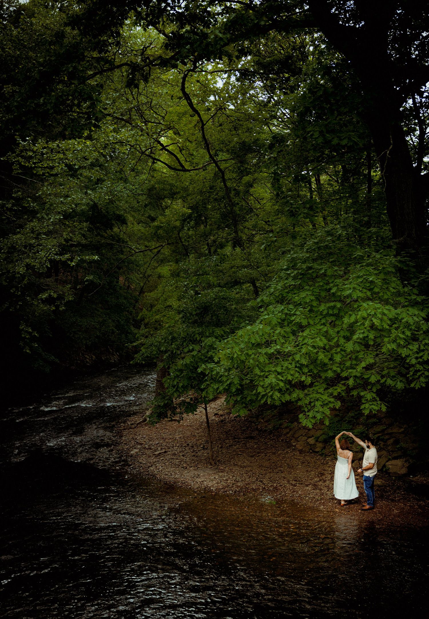 A romantic sequence shows a couple exploring near a forest stream.