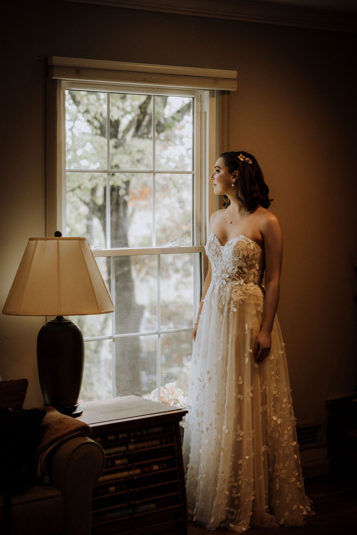 An elegant lace wedding dress photographed in a series of window-lit interior shots.