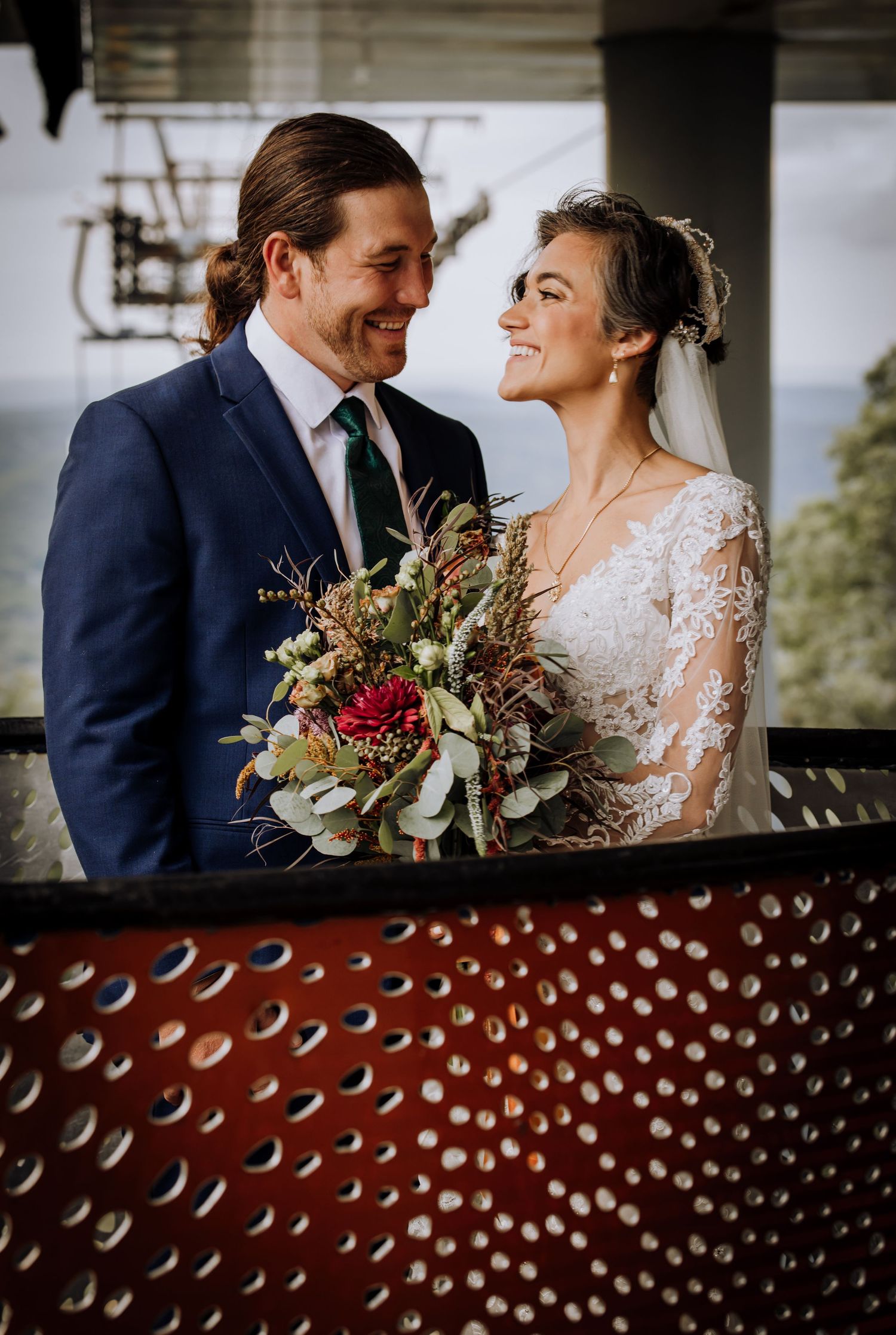 Couple shares intimate moments on their wedding day with rustic decor in background.