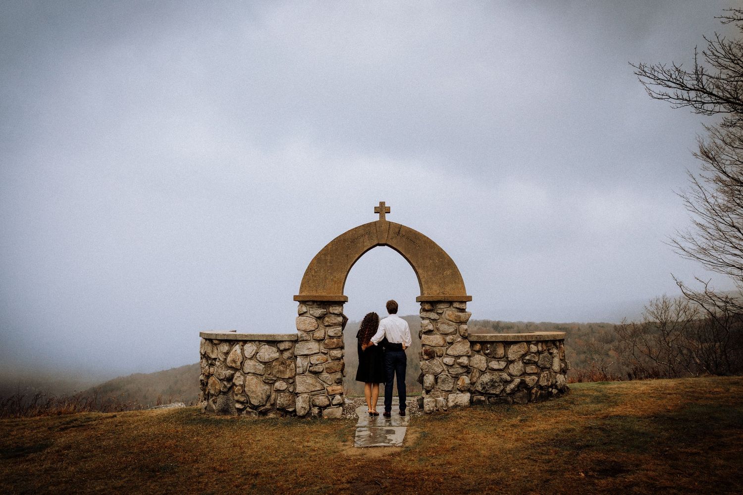 A misty landscape with stone structures and crosses creates a moody panoramic view.