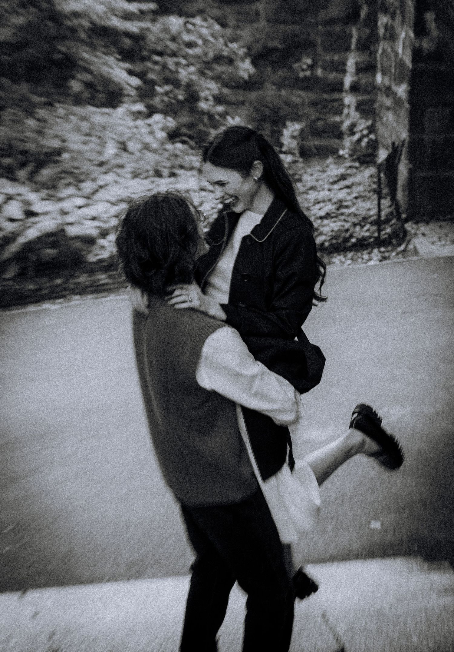 A black and white photo of a couple dancing in an outdoor setting.